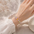 Crystal beaded bracelet on wrist with purple, green, and yellow beads and clear spacers