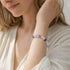 Crystal beaded bracelet with purple amethyst and clear quartz round beads on wrist