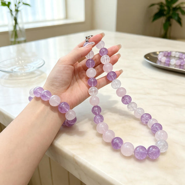 Lilac amethyst-and-quartz beaded necklace and bracelet set on tabletop