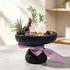Dark stone planter with purple crystal pieces and clear quartz cluster, green air plants, purple ribbon