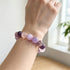 Amethyst and rose quartz beaded bracelet on wrist, purple and pink stone beads