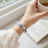 Blue and aqua beaded crystal bracelet on wrist, round stones with clear crystal beads