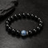 Black bead bracelet with blue round center crystal stone, close-up