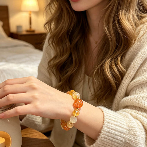 Citrine crystal bracelet on wrist, featuring orange, yellow, and clear bead stones