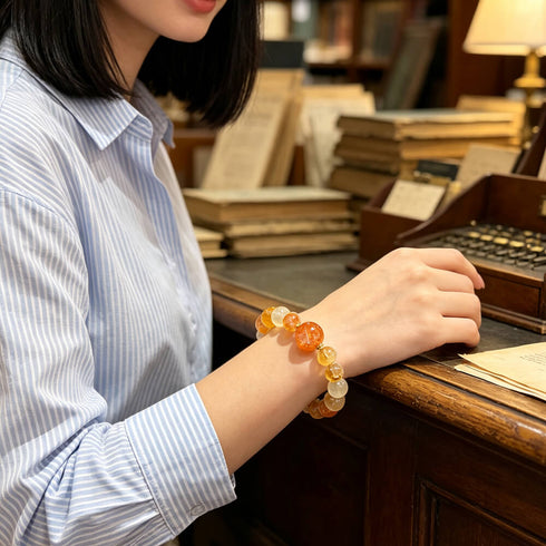 Citrine crystal bracelet worn by a person, orange and yellow beads with clear accents