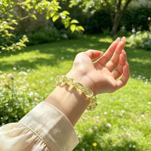 Citrine crystal bracelet worn on wrist, oval faceted yellow stone beads