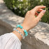 Turquoise and clear crystal bead bracelet on wrist, elastic stretch design