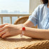 Clear quartz crystal bracelet on wrist with red center bead and clear faceted beads