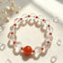 Clear quartz bead bracelet featuring a red round center stone and small red bead accents