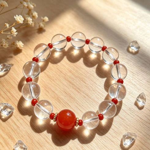 Clear quartz crystal bracelet with red center stone, surrounded by clear faceted beads