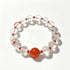 Clear quartz crystal bead bracelet with glossy red center stone and red accent beads