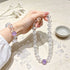 Clear quartz crystal bracelets with round purple amethyst beads held in hand