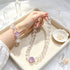 Clear quartz crystal beaded bracelet with round purple amethyst center bead in tray