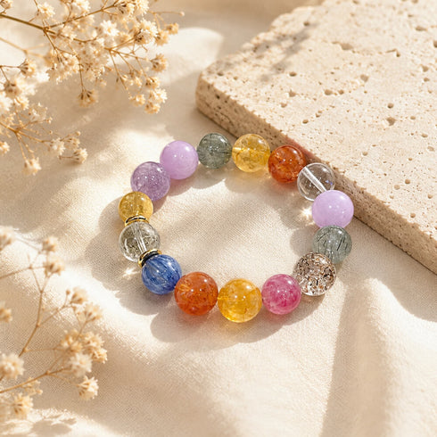 Multi-crystal gemstone bracelet with lavender, blue, orange, and clear beads on fabric