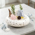 White bowl crystal garden centerpiece with pink crystal, clear rock, gold accent, greenery sprigs