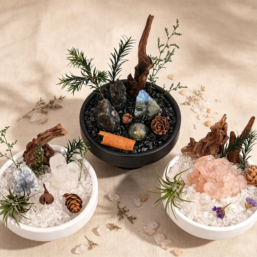Set of three mini crystal garden bowls on a table with assorted crystals and greenery