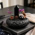 Water intention crystal garden set with black crystal point and purple flowers in dark stone bowl