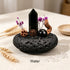 Water intention crystal garden set with black crystal point and purple flowers in dark stone bowl