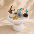 White pedestal crystal tree decor with turquoise bird-like branches, gray crystal, amber nuggets, pinecone