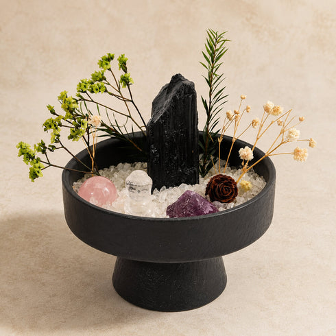 Tabletop crystal garden kit: round black bowl filled with crystals, blooms, and greenery