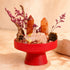 Red tabletop crystal garden centerpiece featuring orange quartz points and rose-colored crystal chunks
