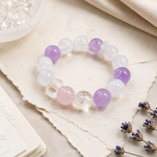 Healing crystal bracelet with pale pink, clear, and lavender beads, including faceted pieces