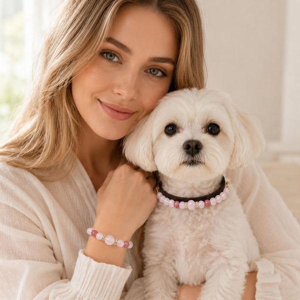 Woman holding a small dog; both feature rose-quartz beaded pet collar and bracelet