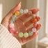Multicolor crystal beaded bracelet in hand with pastel round stones: yellow, pink, green