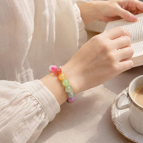 Multicolor beaded bracelet on wrist with pastel round crystals in pink, orange, green