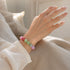 Multicolor crystal bracelet on wrist, round beads in pink, mint, and light green