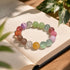 Multicolor beaded bracelet on paper with round pastel crystals in purple, green, pink, and orange