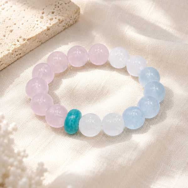 Crystal bead bracelet on cream cloth: pink, white, light blue beads with turquoise center