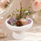 Natural crystal bonsai centerpiece on white stone pedestal with purple crystal and greenery