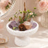 Natural crystal bonsai centerpiece on white stone pedestal with purple crystal and greenery