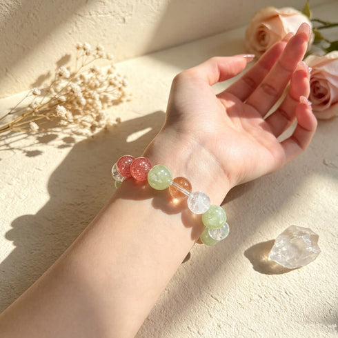 Natural crystal beaded bracelet on open palm, green, clear, pink and yellow beads