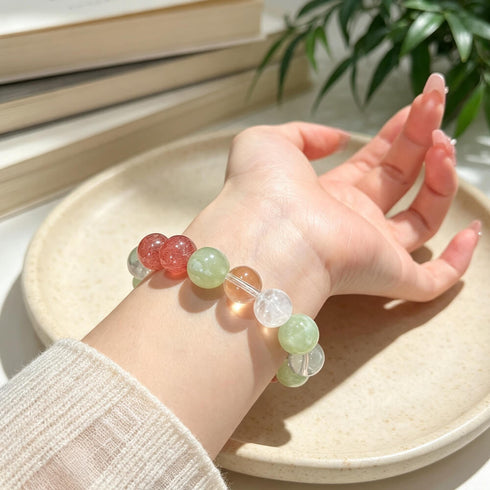 Natural crystal beaded bracelet on hand with sweater cuff, green, clear, pink and yellow beads