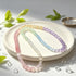 Pastel rainbow beaded bracelet on white tray with pink, mint, blue, and purple beads