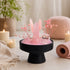 Black pedestal crystal display with pink rose quartz tower, spheres, and floral stems