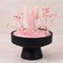 Front view crystal display: black pedestal base with pink rose quartz tower and spheres
