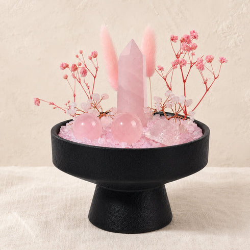 Pink rose quartz crystal centerpiece on black pedestal base with tower, spheres, and stems