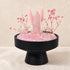 Pink rose quartz crystal centerpiece on black pedestal base with tower, spheres, and stems