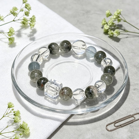 Beaded bracelet in a glass dish with green phantom quartz stones and clear cube centerpiece