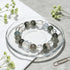 Beaded bracelet in a glass dish with green phantom quartz stones and clear cube centerpiece