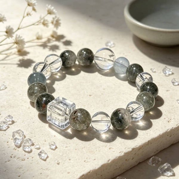 Crystal bead bracelet with dark green quartz rounds, pale blue beads, and clear cube accent