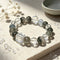 Crystal bead bracelet with dark green quartz rounds, pale blue beads, and clear cube accent