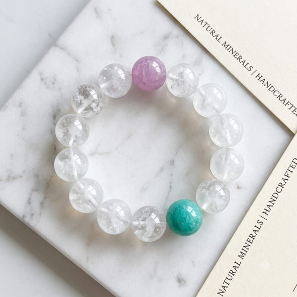 Round crystal beaded bracelet with clear stones, lavender bead, and teal center bead