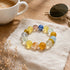 Multicolor round gemstone bead bracelet with clear, yellow, orange, and blue stones