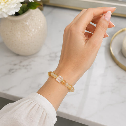 Beaded crystal bracelet on wrist with golden round beads and clear faceted cube accents