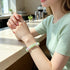 Pastel crystal bead bracelet on wrist with light green beads and clear faceted charm