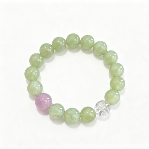 Round gemstone bead bracelet with light green beads, lilac accent, and clear crystal centerpiece